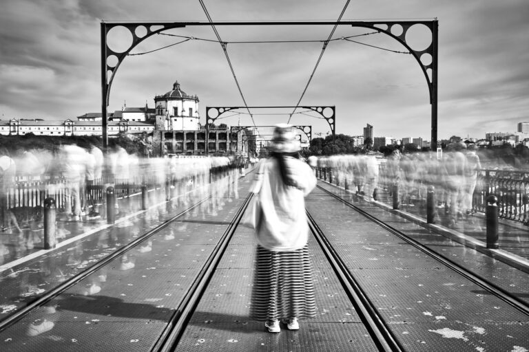 Woman on Luis 1 bridge in Porto with many blurred people