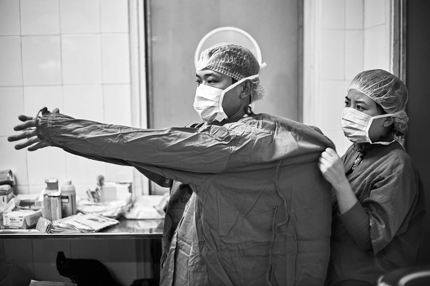 Doctors getting dressed for surgery, Vietnam
