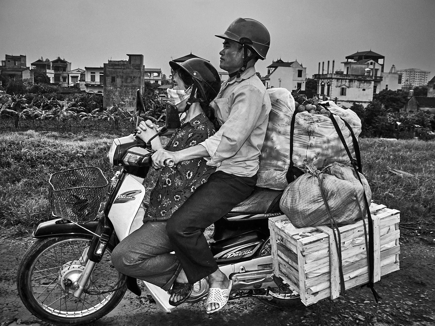 Packed motorbike, with awkward position of woman, in Hanoi