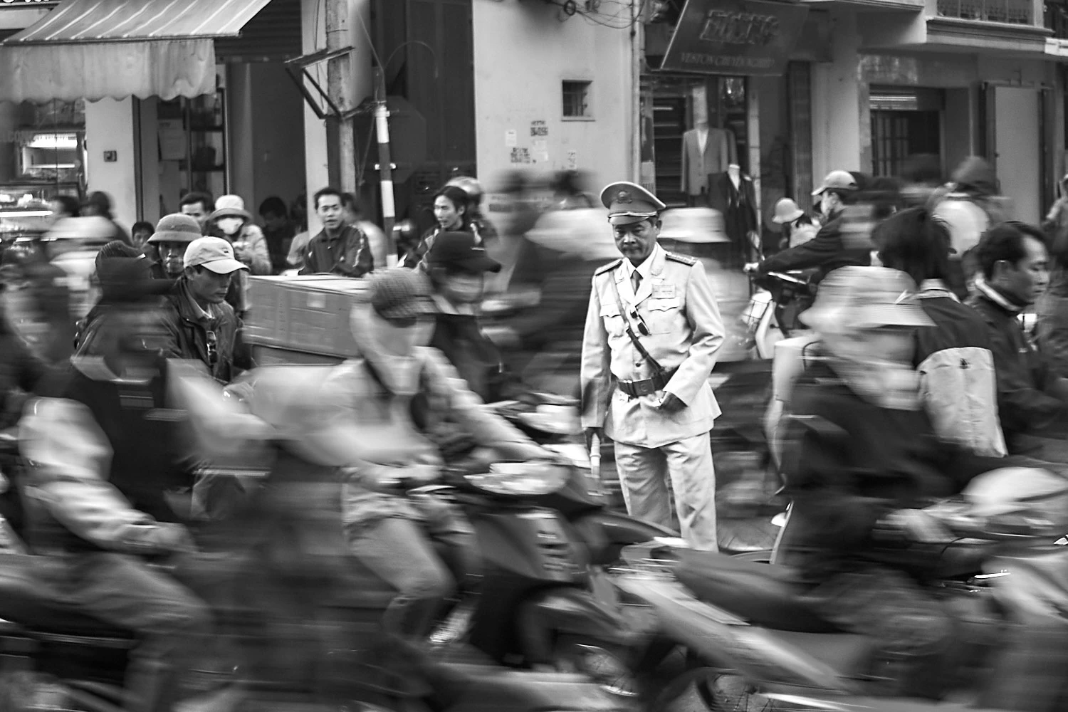 Vietnamese traffic police standing helplessly in a sea of motorbikes