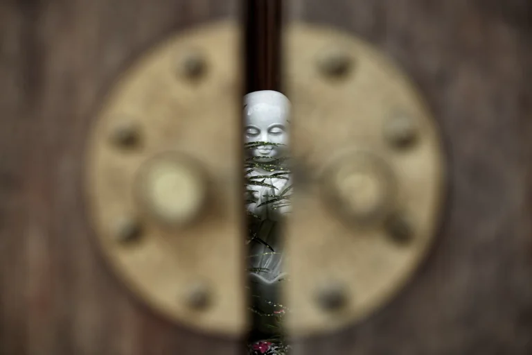 Peeking through an open door at a Buddha statue in Vietnam