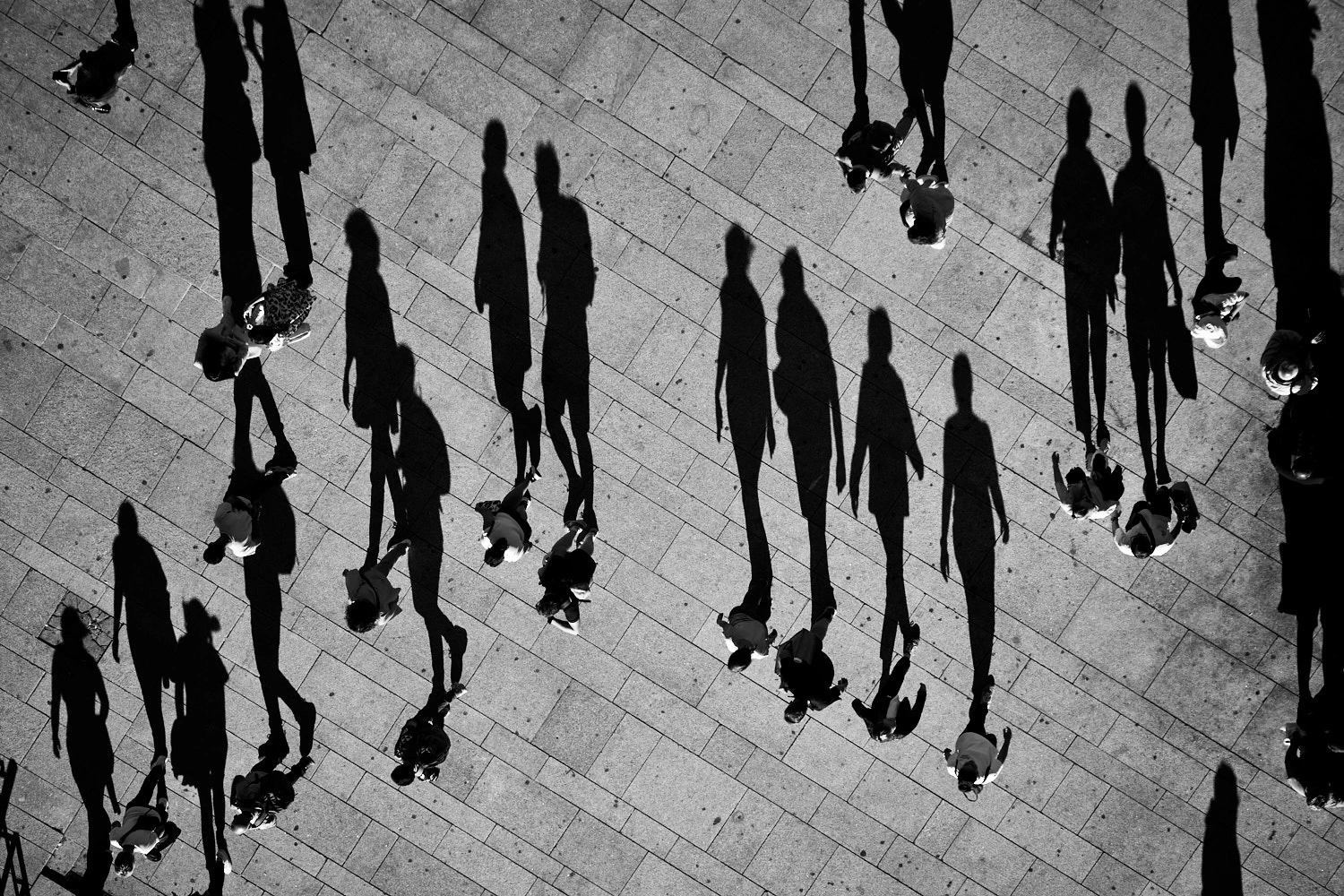 Big walking shadows caused by small people, in Porto