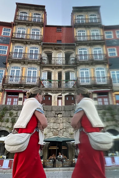 Woman in red reflected in mirror in Porto´s Ribeira district